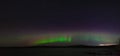 Panoramic view of the aurora borealis. polar lights in the night starry sky over the lake Royalty Free Stock Photo