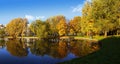 Panoramic view of an autumn park with beautiful reflection of water