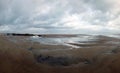 Panoramic view of the beach at sandsend near whitby at low tide with a dramatic stormy cloudy sky reflected in pools of water Royalty Free Stock Photo