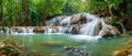 Panoramic view of a beautiful deep forest waterfall in Thailand, surrounded by lush greenery. Ai Generated Royalty Free Stock Photo