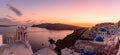 Panoramic view of blue domed churches and bell tower with warm sunset light in Oia, Santorini, Greece Royalty Free Stock Photo