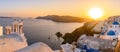 Panoramic view of blue domed churches and bell tower with warm sunset light in Oia, Santorini, Greece Royalty Free Stock Photo