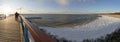 Panoramic view of bridge, sandy beach under snow and ice waves of the Baltic Sea on a sunny day in Palanga, Lithuania Royalty Free Stock Photo