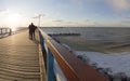 Panoramic view of bridge, sandy beach under snow and ice waves of the Baltic Sea on a sunny day in Palanga, Lithuania Royalty Free Stock Photo