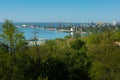 Panoramic view of bustling harbor with cranes. Ships docked at industrial sea port. Urban skyline against clear blue sky Royalty Free Stock Photo