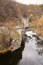 Panoramic view of the canyon. A river with foam flows between the rocks. Steep cliff. Trees are covered with yellow leaves