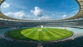 Panoramic view capturing the vast empty stadium featuring meticulously manicured green grass pitch under a bright blue sky with Royalty Free Stock Photo