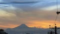 Panoramic view of the Cayambe volcano from the city of Lago Agrio in a sunset with the yellow and red sky