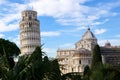 Panoramic view from city wall to leaning tower of Pisa, symbol of Italy, and cathedral with green cypress and palm tree, Tuscany Royalty Free Stock Photo