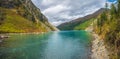 Panoramic view of clear mountain lake in forest among fir trees in sunshine. Bright scenery with beautiful turquoise lake against Royalty Free Stock Photo