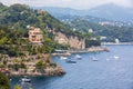 Panoramic view of the coast of Portofino and the Ligurian Sea in the Mediterranean. Trees and vegetation and some boats with