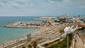 Panoramic view of coast of Tarragona, beach in La Pineda with railway tracks along coastline and port with ships and