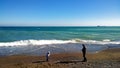 Panoramic view of the coastline with the people strolling in the foreground