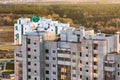 Panoramic view on construction of new quarter Tower unfinished multi-storey high building from a bird`s eye view with forest on