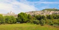 Panoramic view from countryside of the historic town of Assisi in beautiful sunny day with blue sky and clouds in summer, Umbria,