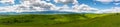 Panoramic view, curving asphalt road on green agricultural fields