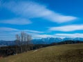 Hilly valley with high snowy Dachstein mountains on the horizon. Upper Austria. Royalty Free Stock Photo