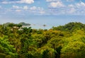 A panoramic view of Dominical Beach in Costa Rica on a mostly sunny day with some puffy white clouds in Central America.