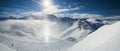 Panoramic view down snow covered valley in alpine mountain range with sundog Royalty Free Stock Photo