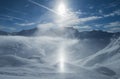 Panoramic view down snow covered valley in alpine mountain range with sundog Royalty Free Stock Photo