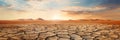 Panoramic view of dry cracked land at sunset, landscape of dry deserted ground in summer. Concept of soil, drought, global warming Royalty Free Stock Photo