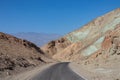 Death Valley - Panoramic view of endless empty road leading to colorful geology of multi hued Artist Palette rock formations