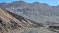 Death Valley - Panoramic view of endless empty road leading to colorful geology of multi hued Artist Palette rock formations