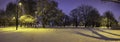 Panoramic view of evening winter landscape. View of covered in snow trees in park and street lights Royalty Free Stock Photo