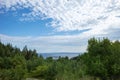 panoramic view of the forest with hills and the sea against a background of blue sky with clouds Royalty Free Stock Photo