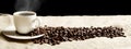 Panoramic view of frothy coffee cup with beans on fabric flax