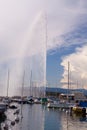 Panoramic view of Geneva skyline with famous Jet d\'Eau fountain and traditional boat at harbor district, Royalty Free Stock Photo