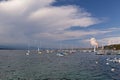 Panoramic view of Geneva skyline with famous Jet d\'Eau fountain and traditional boat at harbor district, Royalty Free Stock Photo