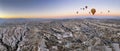 panoramic view of a goup of hot air balloons flying over the fairy chimneys, at the Goreme airfield at dawn, Cappadocia, Turkey, Royalty Free Stock Photo