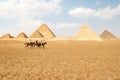 Panoramic view of Great Egyptian pyramids in Giza and three riders in front of them