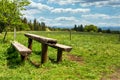 Panoramic view of green valley and rest area with wooden bench Royalty Free Stock Photo