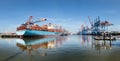 Panoramic view on harbor of hamburg with bright blue cargo ship