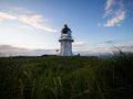 Panoramic view of historic white lighthouse landmark perched on oceanside clifftop Cape Reinga Northland New Zealand Royalty Free Stock Photo