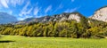 Panoramic view of idyllic mountain scenery in the Alps with fresh green meadows in bloom on a beautiful sunny day in springtime