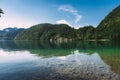 Panoramic view of idyllic summer landscape in the Alps with clear mountain lake and fresh green mountain pastures in the Royalty Free Stock Photo