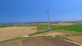 Panoramic view of industrial windmills with summer meadows