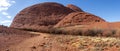 Panoramic view of Kata Tjuta - Mount Olga, Valley of the winds. Walking path towards the mountain. Dry vegetation at the sides.