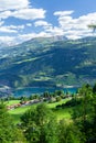 Panoramic view of lake, countryside, green alpine meadows and mountains