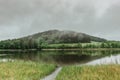 Panoramic view of a lake in front of misty forest. Foggy morning outdoors.Beautiful autumn spring landscape with hill and water Royalty Free Stock Photo