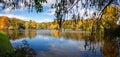 Panoramic view of the lake at Stourhead in full autumn colours of yellow, gold, orange and red at Stourton, Wiltshire, UK