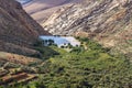 Panoramic view at landscape between Betancuria and Pajara  on Fuerteventura with dammed lake and multi colored volcanic mountais Royalty Free Stock Photo