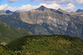 The landscape with mountains and green hills in the foreground against a blue sky with clouds on Mount Cimetta, in Switzerland Royalty Free Stock Photo