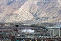 The panoramic view of Lhasa city, in front of Potala Palace and Palace square, with modern building and mountains, far away a Tib