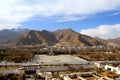 The panoramic view of Lhasa city, in front of Potala Palace and Palace square, with modern building and mountains, far away a Tib Royalty Free Stock Photo