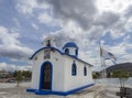 Panoramic view of Little beautiful Greek church in blue and white colors on a sunny day with cumulus clouds of NEA Artaki on the i