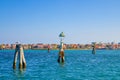 Panoramic view of Lusenzo lagoon with wooden bricole poles in water and Sottomarina town